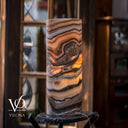 Illuminated Sahara Onyx cylinder table lamp glowing with cream, honey, caramel, and mocha natural stone banding