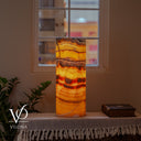 Illuminated Miami Sunset Onyx cylinder lamp glowing with golden orange, amber, red, and dark brown banding
