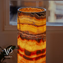 Miami Sunset Onyx bedside lamp glowing warmly with vivid yellow, rust red, and charcoal stone patterns