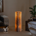 Sculptural Aqua Onyx tower illuminated to showcase vertical cream, honey, amber, and brown mineral movement