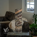 Unlit side of a Tangerine Onyx cylinder lamp with a distinctive cream-colored curl through dark brown stone.