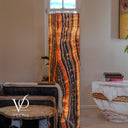 Angled view of the glowing Tangerine Onyx tower showing orange and charcoal patterns across two sides beneath a window.