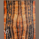 Close-up of illuminated Tangerine Onyx showing fine crystalline texture between wavy charcoal and glowing amber bands.