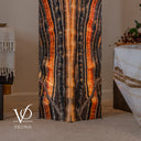 Lower detail of an illuminated Tangerine Onyx floor lamp with orange vertical bands and thin diagonal veins near the base.