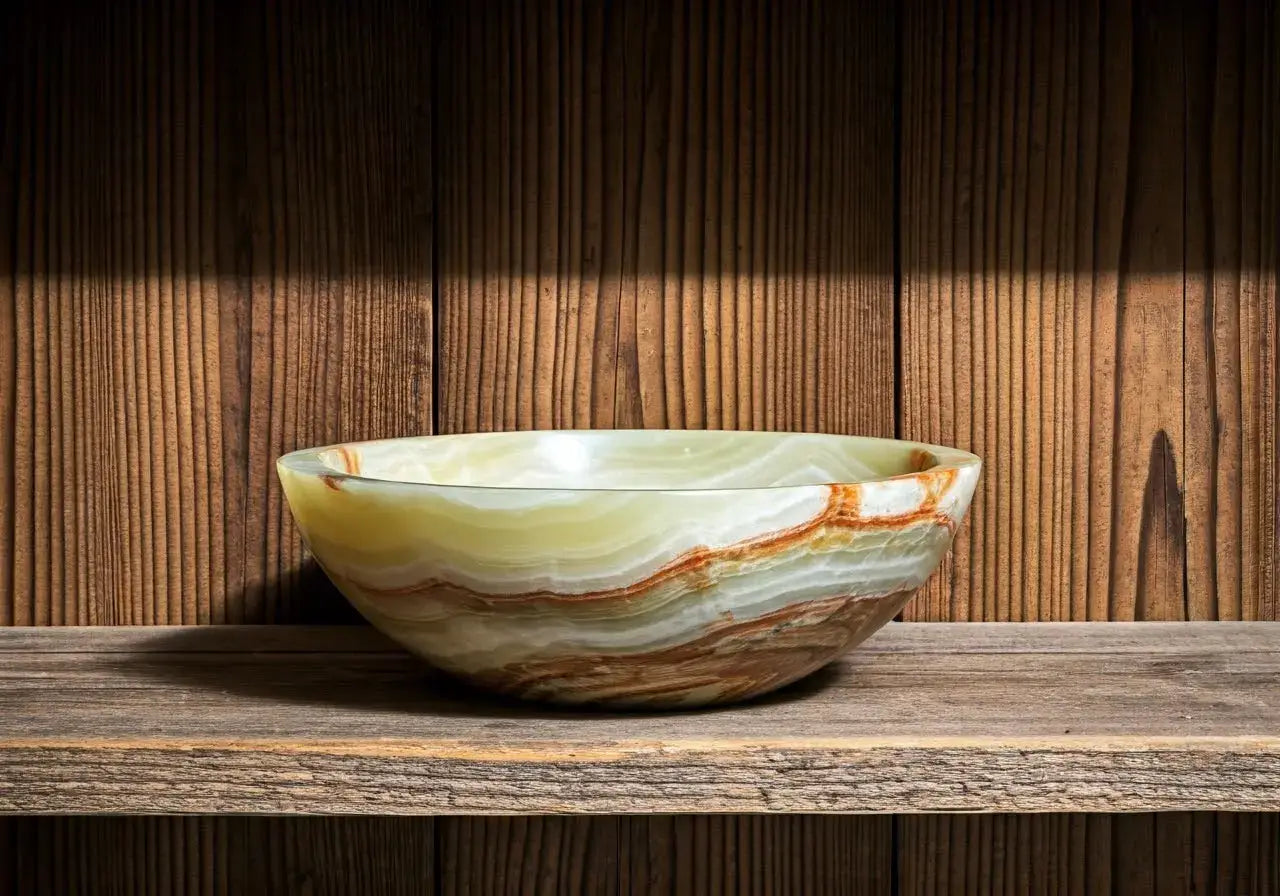 A polished onyx bowl displayed on a rustic wooden shelf. 35mm stock photo