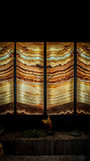 Four-panel illuminated onyx wall art with warm amber, gold, and teal layered patterns.