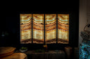 Four-panel illuminated onyx wall art with warm amber, golden, and cream-colored concentric bands.