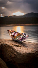 Glass boat on rock at sunset