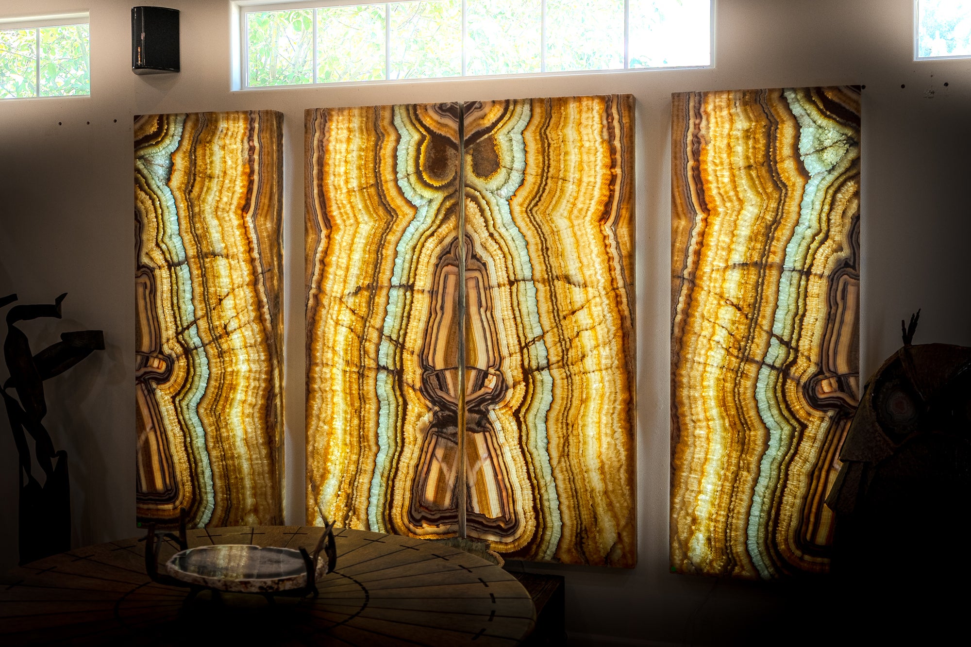 Three illuminated natural onyx wall panels with bookmatched mineral movement