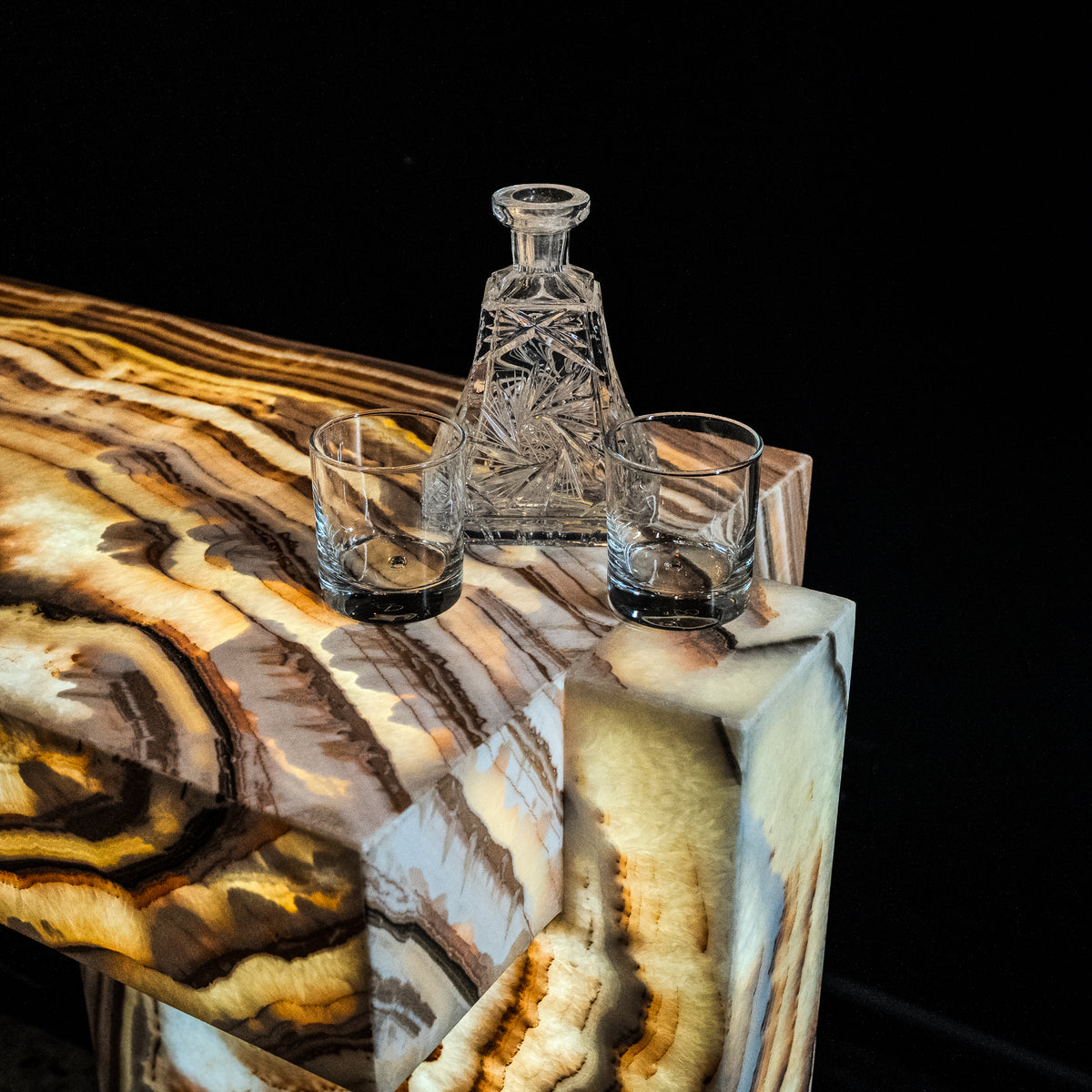 Polished natural onyx table with flowing dark and cream mineral banding