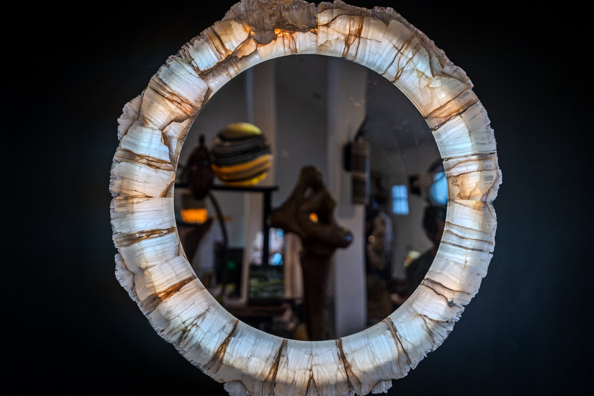 Round mirror framed by translucent white natural onyx