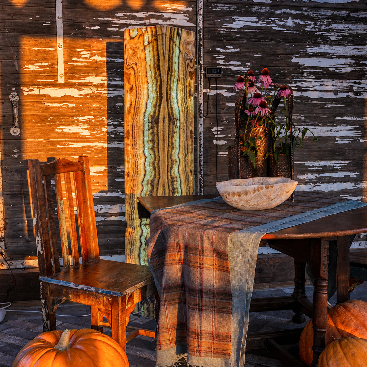 Natural onyx wall art, tower lamp, and sculptural bowl displayed in a rustic interior