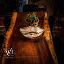 Wooden table with a decorative bowl and potted plant, featuring the Vilona logo.