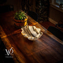 Wooden table with a decorative bowl and potted plant, illuminated by warm sunlight.