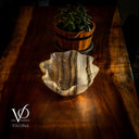 Decorative agate stone on a wooden surface with a potted plant in the background, featuring the brand 'Vilona'.