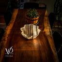 Wooden table with a decorative shell and potted plant, branded 'Vilona'.