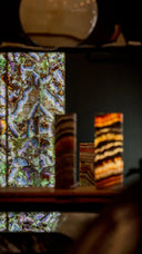 A rectangular, vertically oriented agate slab with vibrant orange and brown concentric bands.