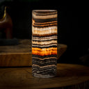 Striped agate cylinder lamp with warm glow, natural stone material.