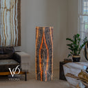 Illuminated Tangerine Onyx floor lamp glowing with orange, amber, cream, charcoal, and black vertical banding