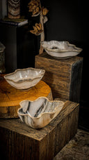 Three handcrafted agate bowls with natural, swirling marbled patterns in shades of white, gray, and beige, each featuring a scalloped edge.