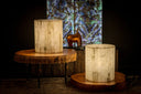 Two cylindrical log side tables with a natural wood grain finish and rustic, round tops.