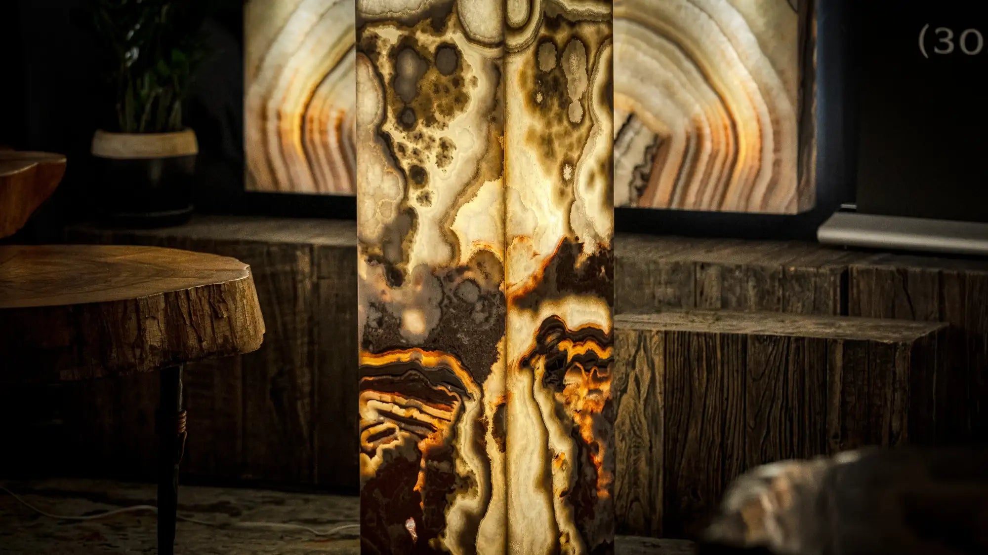 A striking, vertically oriented onyx panel with swirling amber and cream patterns illuminated from within.